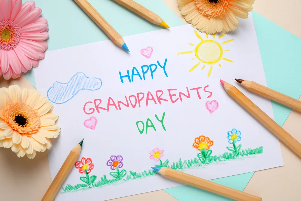Flat lay composition with drawing for Grandparents day on table